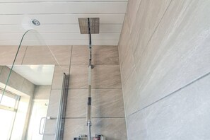 A modern bathroom with a glass shower enclosure, a visible showerhead, and a tiled floor. - Modern 2BR Apartment, S1 City Centre, WIFI, Sleeps 6 (Greater Manchester)