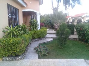 Ein gepflegter Garten mit einem Kiesweg, der zum Hauseingang führt.