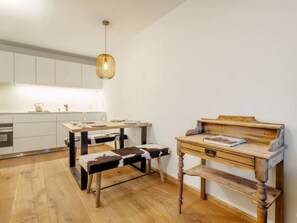 Una cocina moderna con armarios blancos, una mesa de comedor de madera y un banco.
