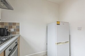 Eine Küche mit Herd, Backofen und einem weißen Kühlschrank.