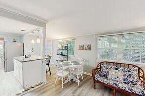 A kitchen with a dining area, a sofa, and a window with blinds. - Beachy dog-friendly home, blocks to the restaurants, fishing pier & beach (Tybee Island)