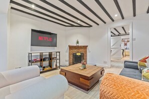 A modern living room with a fireplace, a flat-screen TV, and a bookshelf. - Traditional 2 Bed Cottage, Otford, Games Room, Sleeps 4, Parking (Otford)