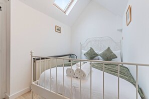A bedroom with a white metal bed frame, a skylight, and a single bed with green pillows. - Traditional 2 Bed Cottage, Otford, Games Room, Sleeps 4, Parking (Otford)