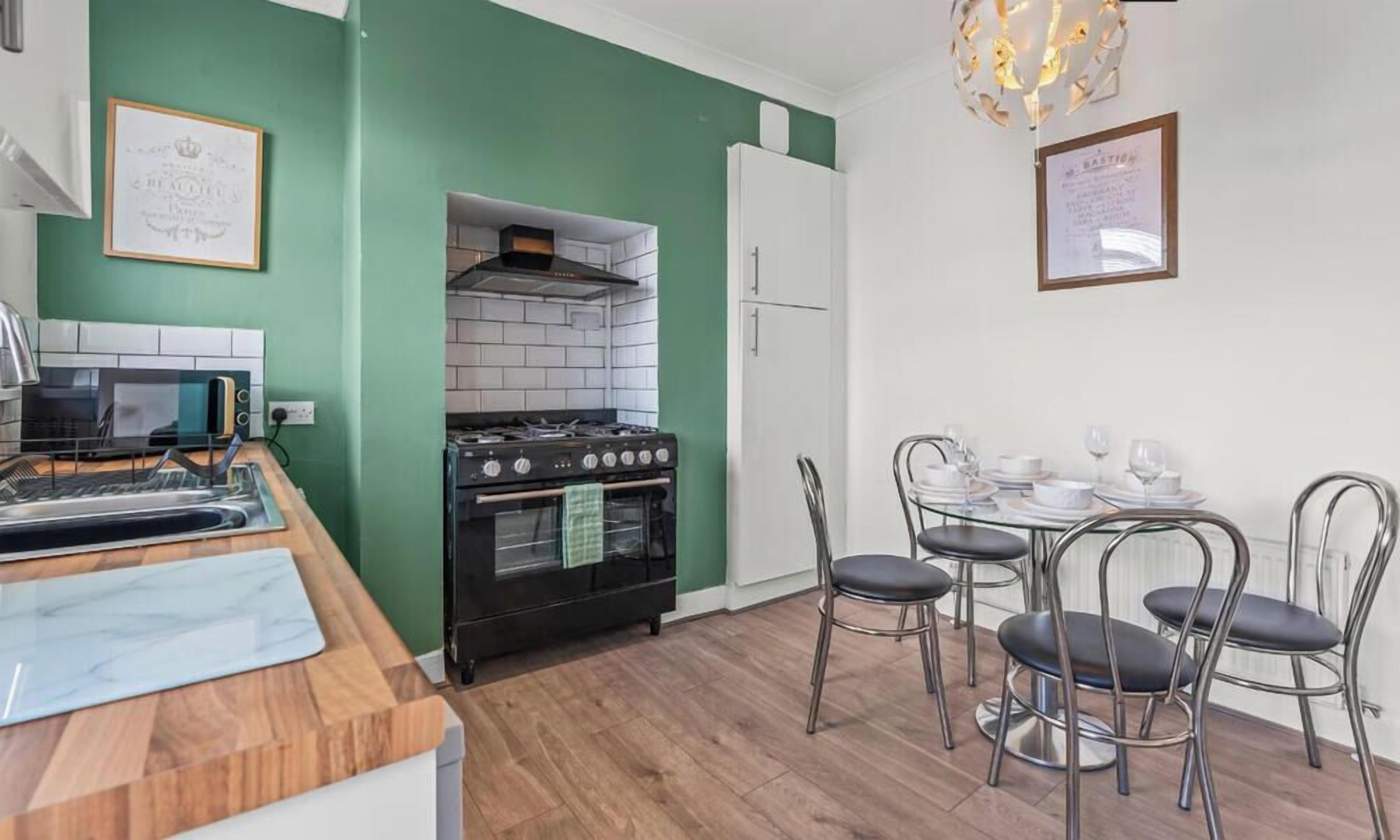 Cocina compacta con estufa, horno y microondas. Cuenta con una zona de comedor con mesa y sillas.