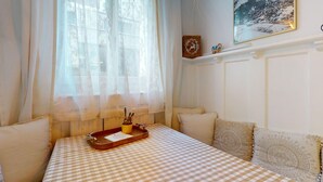 Una habitación con una colcha a cuadros, una bandeja de madera con un cactus y un cuadro en la pared.