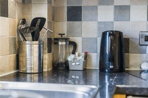 Eine Küche mit Kaffeemaschine, Mixer und Geschirrhalter.