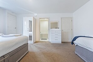 Ein Schlafzimmer mit einem Bett, einem Schminktisch, einem Kleiderschrank und einer Tür.