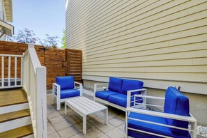 An outdoor patio with white furniture and a wooden fence. - Newly Built Two-Story Townhouse w/Free WiFi, Washer/Dryer, and Central A/C (Savannah)