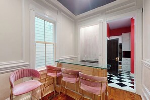 A kitchen with a glass-top table, pink chairs, and a checkered floor. - Designer home in Historic District with upscale kitchen (Savannah)