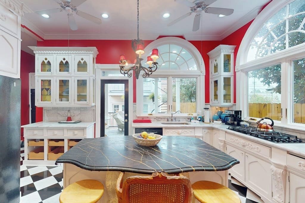 A kitchen with a central island, white cabinetry, and a chandelier.