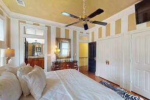 A bedroom with a bed, a ceiling fan, a dresser, and a mirror. - Designer home in Historic District with upscale kitchen (Savannah)