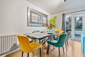 A dining area with a table, chairs, and a plant. - Large 4 Bedroom House Bricket Wood, Van & Car Parking, Sleeps 8 (Bricket Wood)