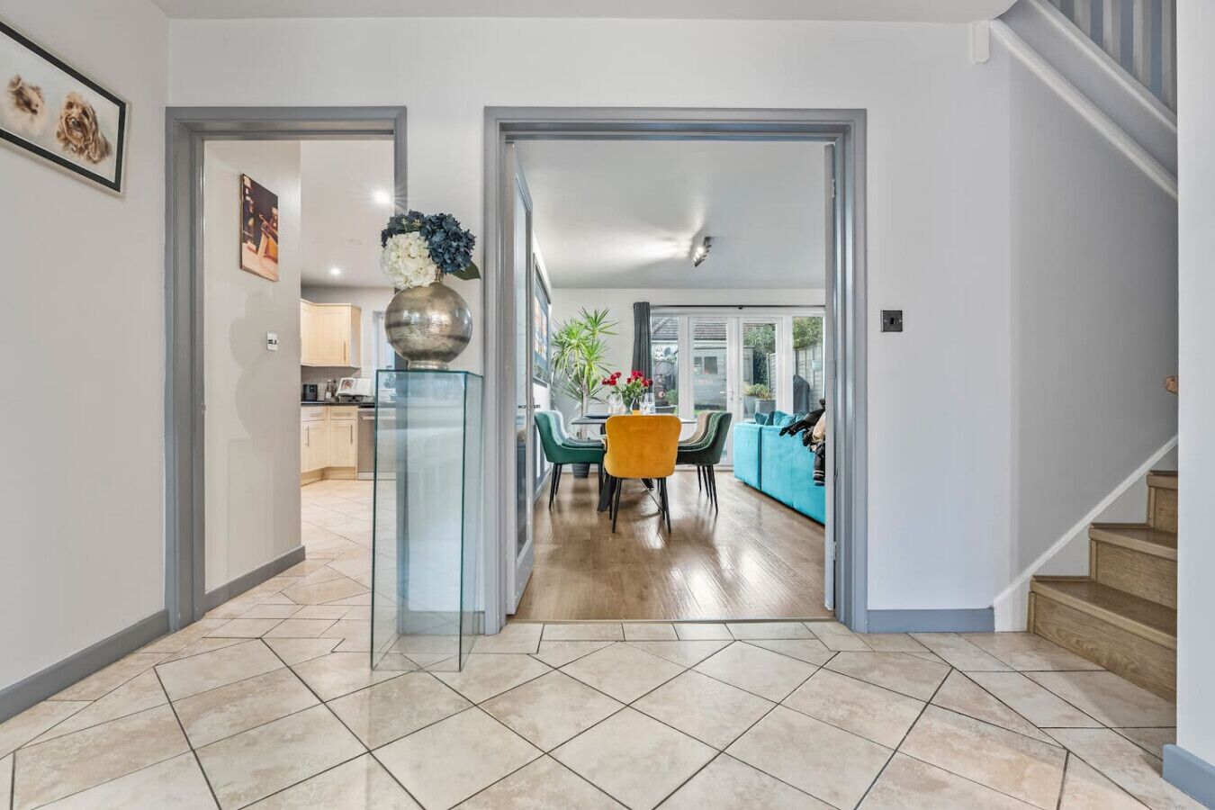 A modern interior with a dining area, kitchen, and staircase.
