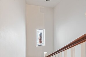 Eine Treppe mit Holzgeländer und einem kleinen Fenster mit Blick ins Freie.