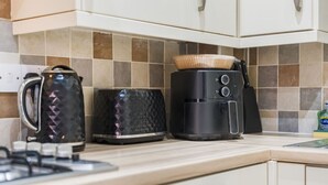 Eine Küche mit Wasserkocher, Toaster und Kaffeemaschine auf der Arbeitsfläche.