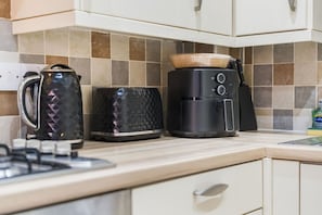 A kitchen with a kettle, toaster, and coffee maker on the countertop. - Central Derby Stay | Comfort for 4 | Wi-Fi (Derby)