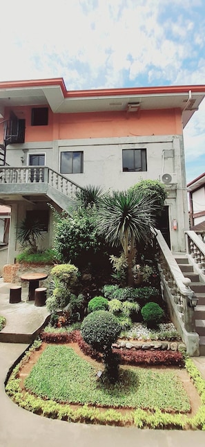 Un edificio de dos pisos con un balcón y una escalera.