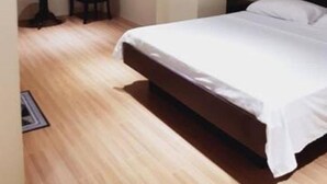 Ein Schlafzimmer mit einem großen Bett, einem kleinen Tisch und einem Stuhl.