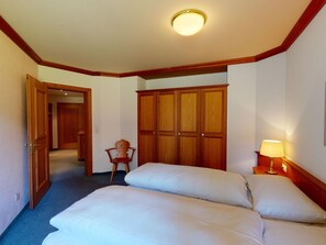 Ein Hotelzimmer mit einem Bett, einem Sessel, einem Kleiderschrank und einer Lampe.