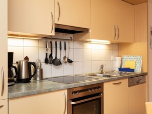 Eine Küche mit Herd, Backofen und Kaffeemaschine.