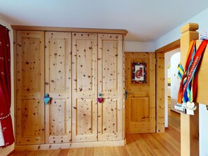 Ein Holzkleiderschrank mit mehreren Türen, ein kleiner Bilderrahmen und eine Medaillenleiste.