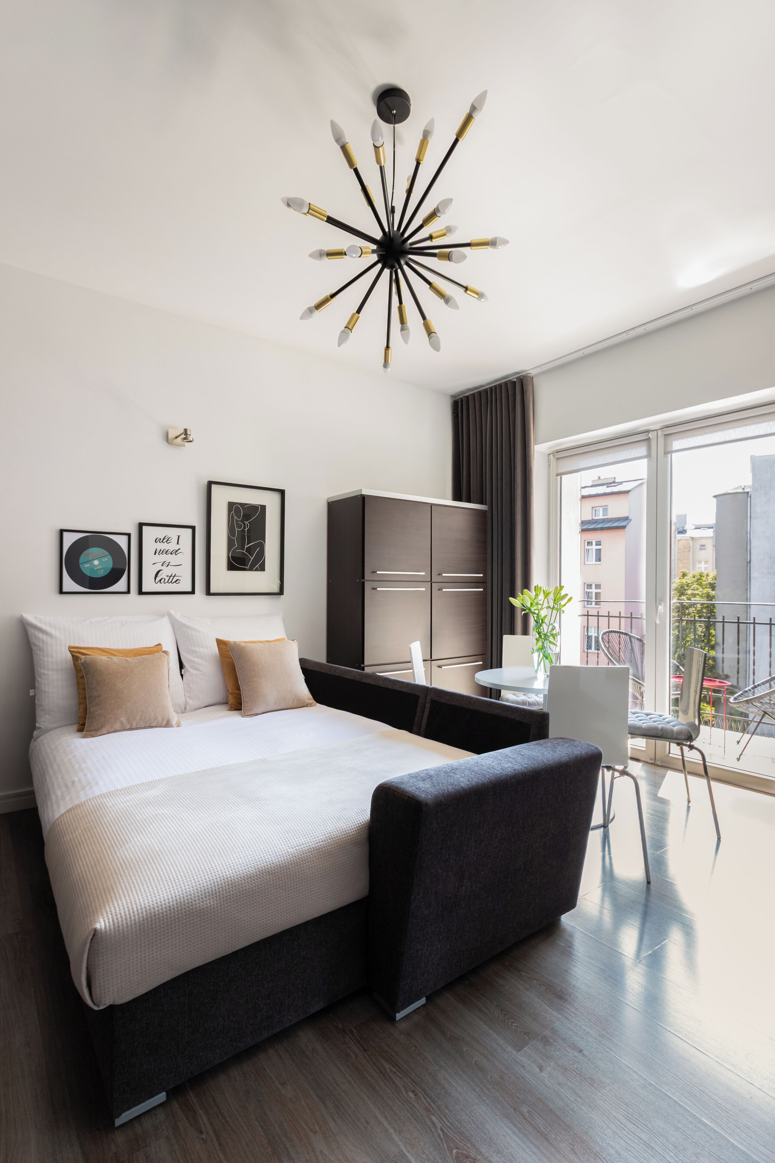Ein modernes Schlafzimmer mit einem großen Bett, einem Schreibtisch und Blick auf die Stadt.