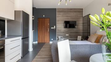 A modern bedroom with a bed, bedside table, and a large window.