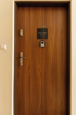 A wooden door with a number plaque indicating room 24, a keyhole, and a door handle. - Native Apartments Morawskiego 12 (Kraków)