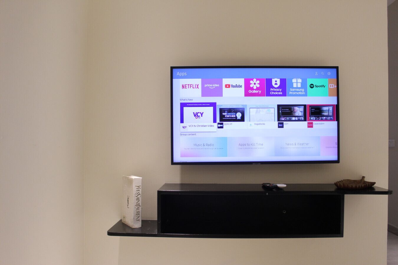 Un téléviseur à écran plat fixé au mur affiche une variété d’icônes d’applications, notamment Netflix et YouTube.