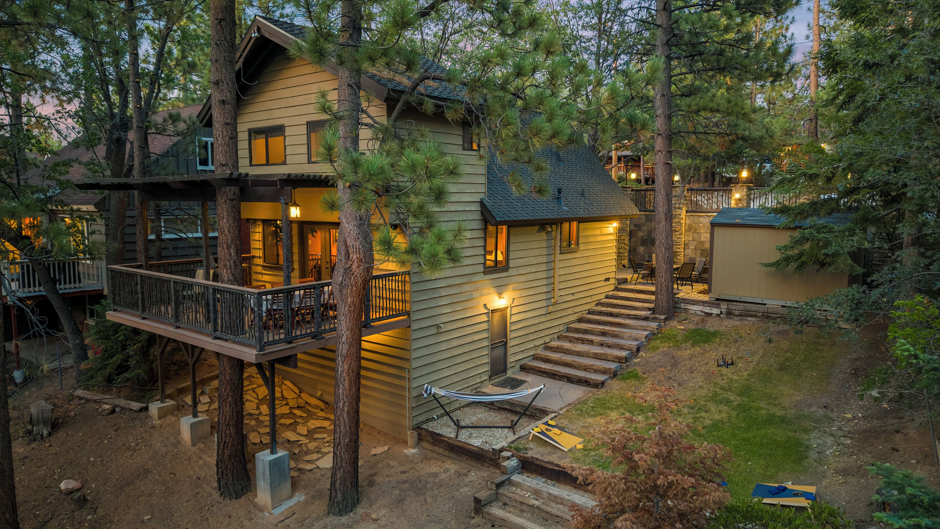Une cabane avec une terrasse, un hamac et un sentier pavé de pierres.