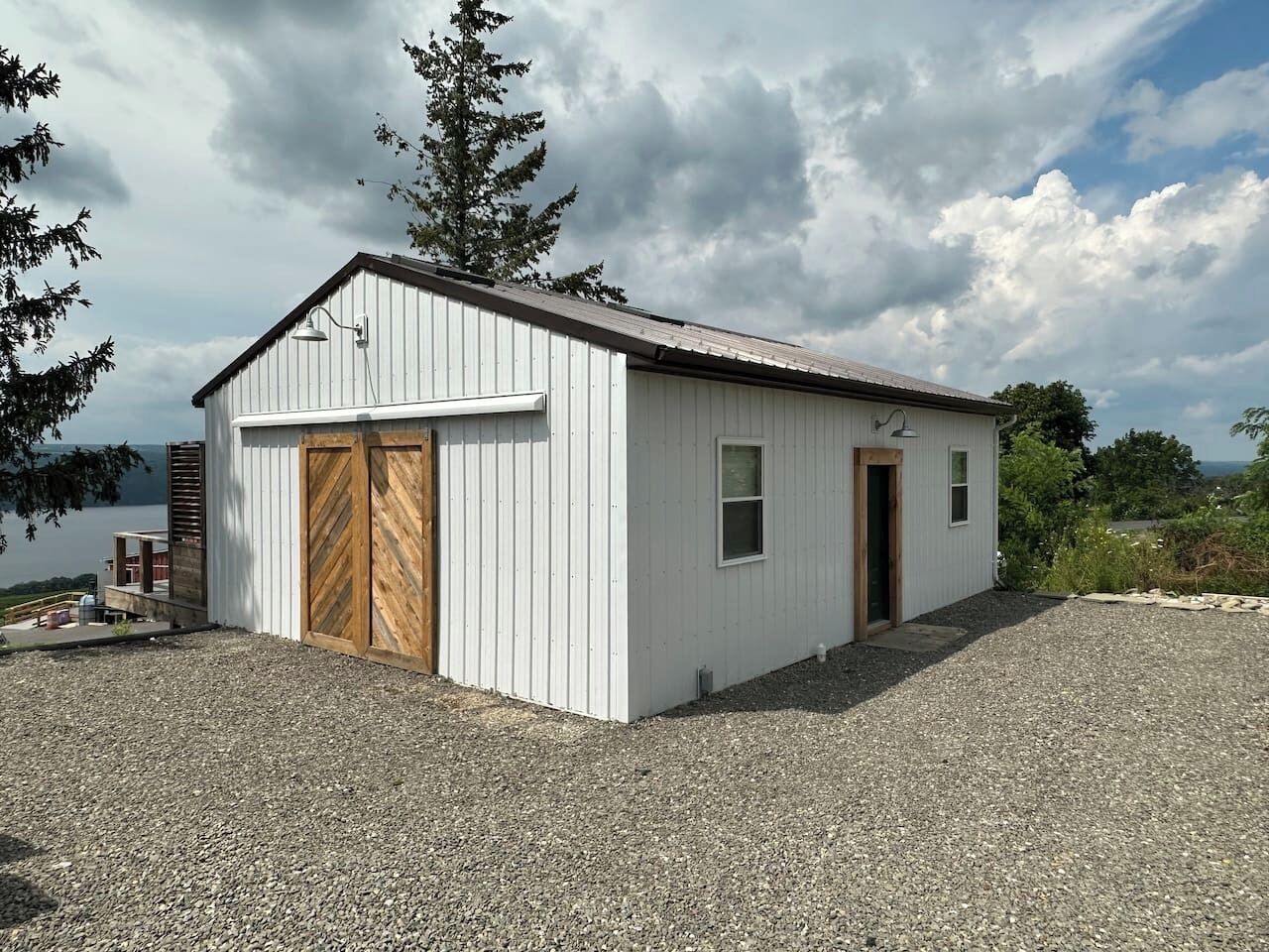 A single-story building with a white exterior, a wooden garage door, and a small window.