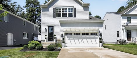 A two-story residential house with a garage, a front lawn, and a satellite dish.