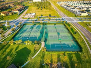 An aerial view of a residential area with multiple tennis courts, a road, and houses. - Epic Villa By Disney Theater Game Room Pool Spa (Davenport)