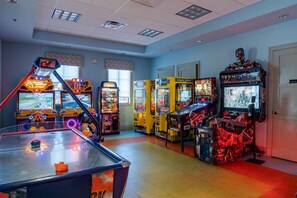 Ein Spielhallenraum mit verschiedenen Spielautomaten, darunter Renn- und Schießspiele.