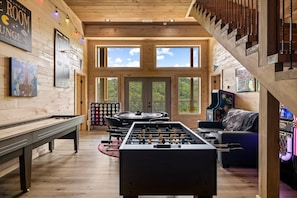 A cozy room with a foosball table, a pool table, and a piano. - Tennessee Sunrise 3 Bedroom Cabin (Sevierville)