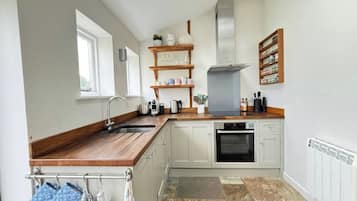 A kitchen with a built-in oven, a sink, and a window.
