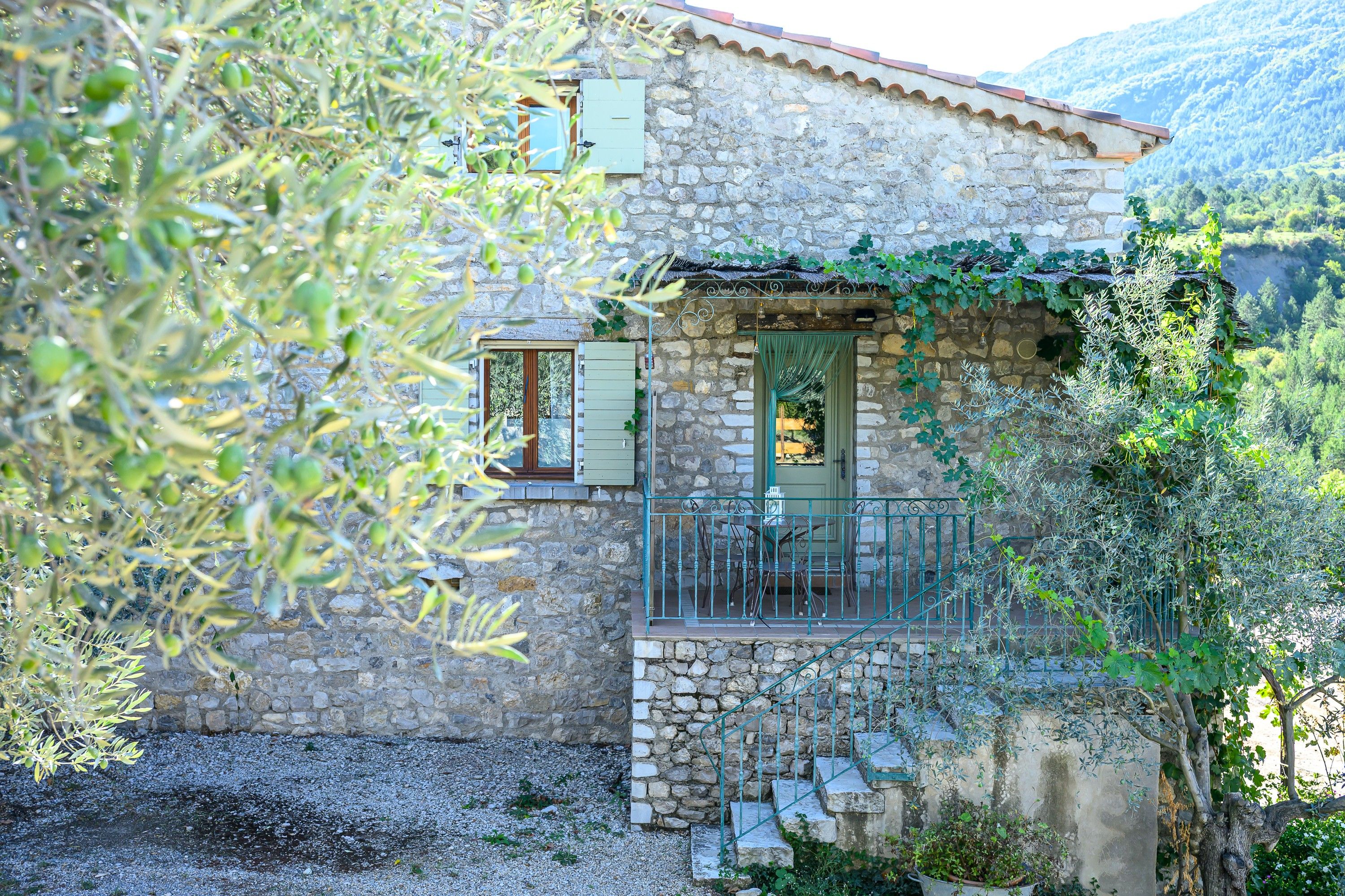 Una casa de piedra con balcón, una ventana y una puerta.