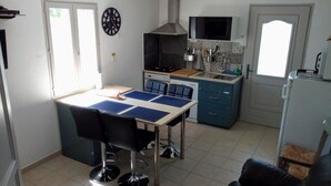 Cocina compacta con una mesa de comedor, sillas y un microondas.