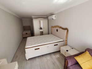 A compact bedroom with a single bed, a wardrobe, a small bedside table, and an air conditioning unit. - zeyos lodge (Kumluca)