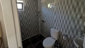 A bathroom with a shower, toilet, and sink. - zeyos lodge (kumluca)