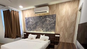 Un dormitorio moderno con una cama grande, un televisor de pantalla plana y piso de mármol.
