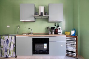 A compact kitchen with a built-in dishwasher, a sink, and a coffee machine. - Terrazze Arenella Guest House: Sea View, Wi-Fi, Air Conditioning (Palermo)