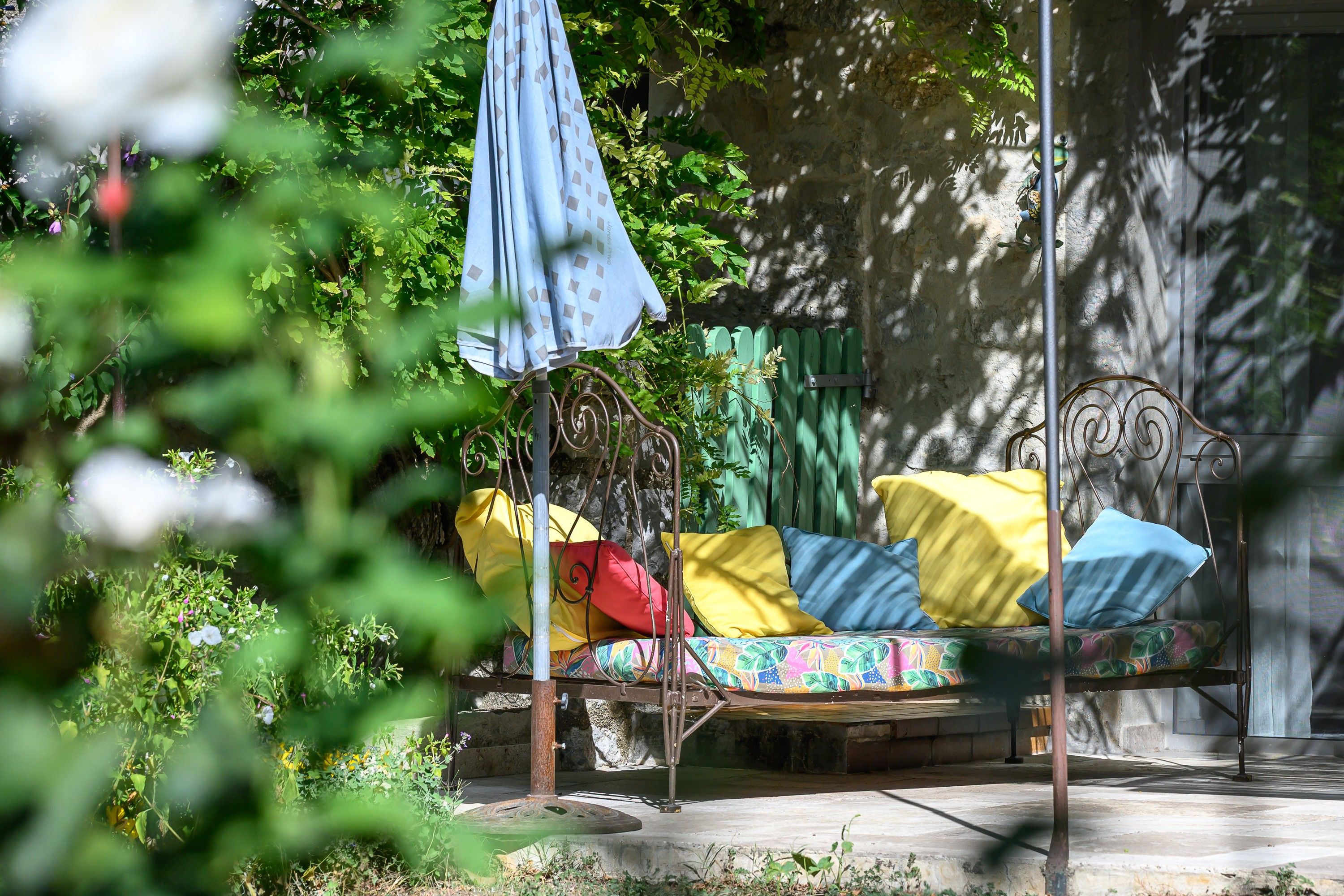 A bed with a metal frame, a patterned mattress, and pillows in yellow and blue.