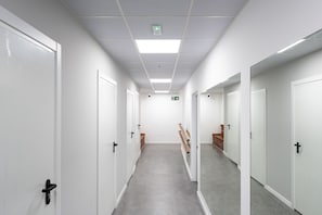 A corridor with white doors, a grey floor, and a ceiling with recessed lighting. - MalagaSuite Urban Beach A (Torremolinos)