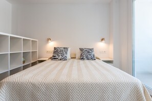 A hotel room with a large bed, two nightstands, a white wardrobe, and a window. - MalagaSuite Urban Beach A (Torremolinos)