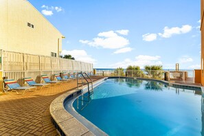 A swimming pool with lounge chairs and a view of the sea. - Luxurious Beach-Front Condo, Huge Balcony, New Rental, Remodeled in 2026! (Panama City Beach)