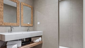 Ein modernes Badezimmer mit zwei Waschbecken, einem großen Spiegel und einer Badewanne.