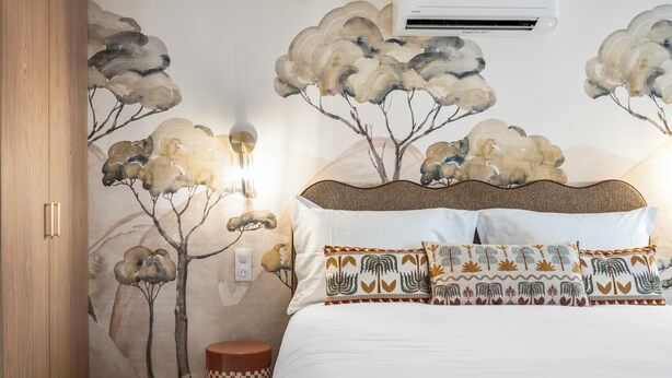 A bedroom with a bed, pillows, a wall-mounted air conditioner, and a wall with a nature-themed mural. - Theava Collection -Citadelle- St Tropez (Saint-Tropez)