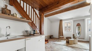 A kitchen with a wooden staircase, white cabinets, and a brick floor. - Theava Collection -Citadelle- St Tropez (Saint-Tropez)