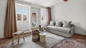 A living room with a sofa, a chair, a small table, and a window with curtains. - Theava Collection -Citadelle- St Tropez (Saint-Tropez)